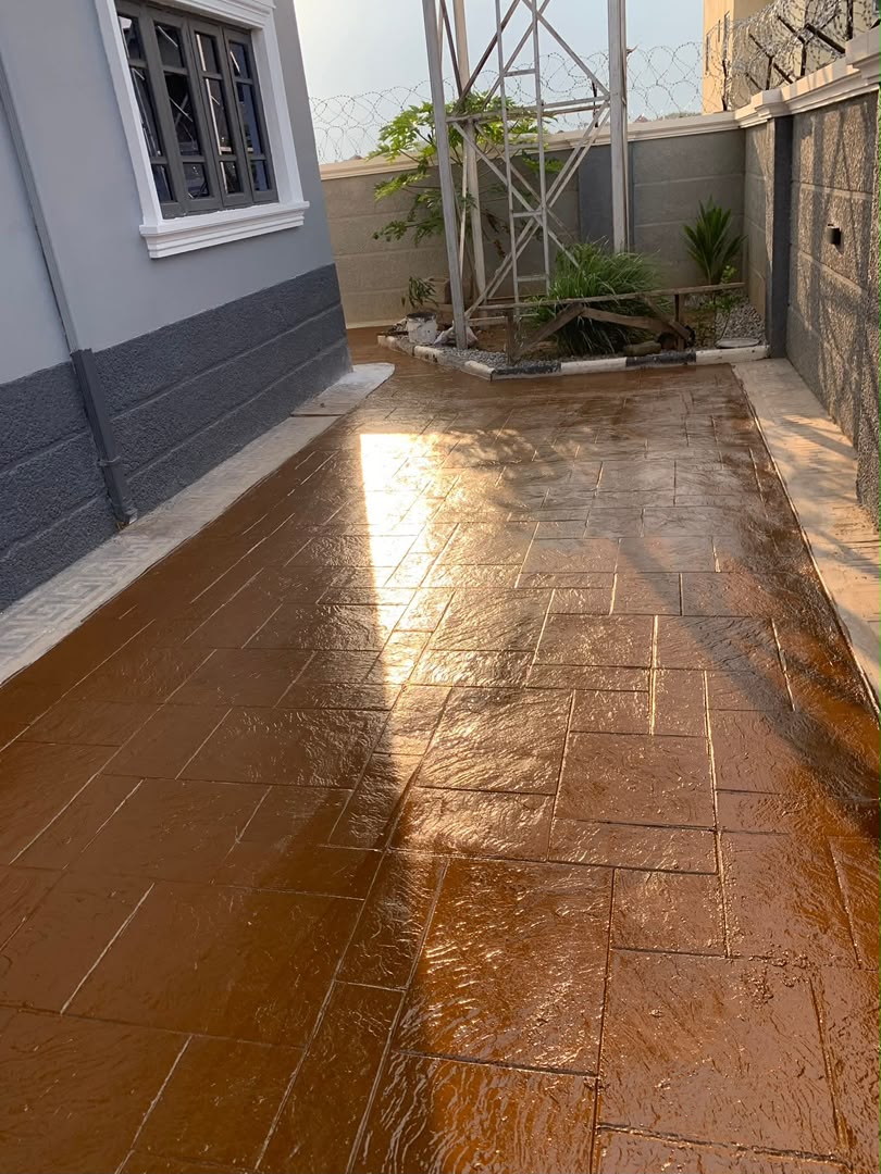 Glossy sealed ashlar stamped concrete side walkway beside a home