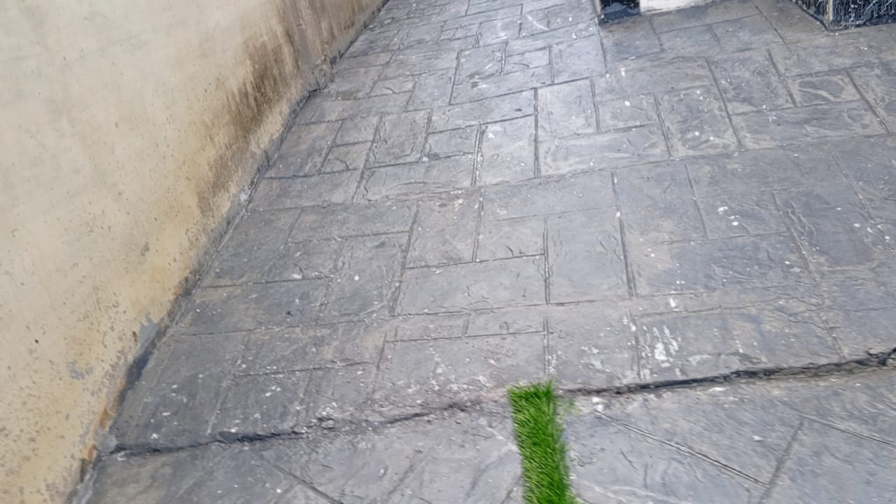 Charcoal ashlar stamped concrete pathway running along a boundary wall